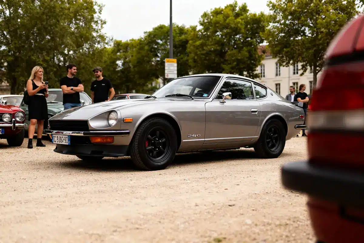 Voiture argentée Datsun 240z automatic lors d'un rassemblement automobile en plein air