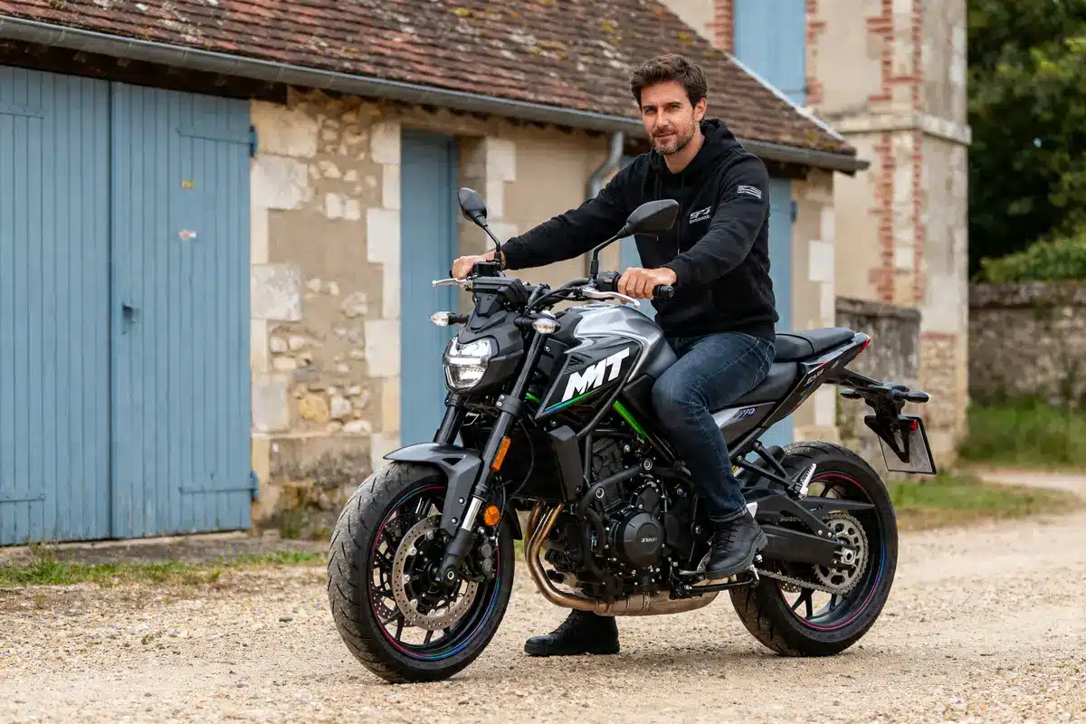 Homme posant sur la moto MT07 2024 devant une maison en pierre